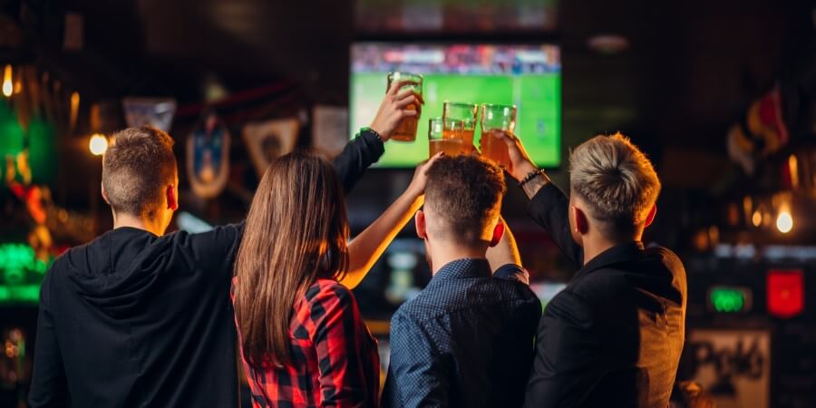 friends watches football on tv in a sport bar P4XERND 1
